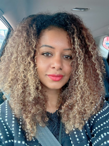 Selam Emiru founder of Glisen with her dyed hair in a wash and go style